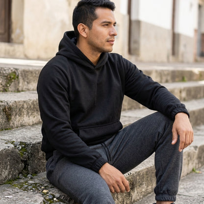 Hombre sentado con buzo con capota y jogger